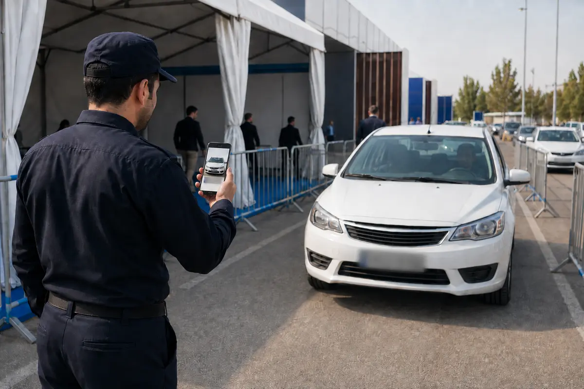 نگهبان در حال ثبت ورود خودرو با دوربین تلفن همراه